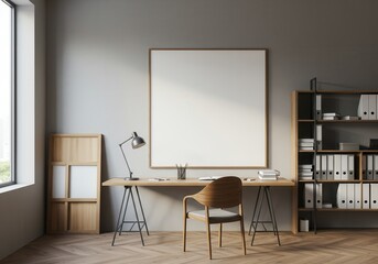 Minimalist office space with a wooden desk, chair, lamp, and a large blank picture frame on a gray wall