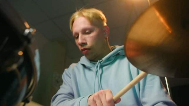 Musician demonstrating different drumming techniques on a drum kit, hitting the snare, and cymbal work, showcasing rhythmic skills and musical talent. Drummer playing various drumming techniques