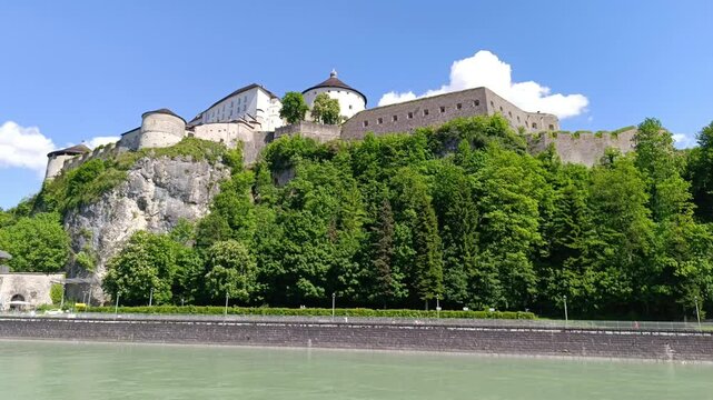 Explore Kufstein Fortress overlooking the serene Inn River in Tyrol, Austria, surrounded by lush greenery and breathtaking landscapes on a sunny day