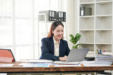 Fototapeta premium Smiling Asian Businesswoman Working at Desk