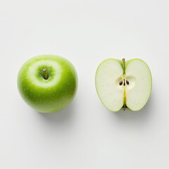 Whole green apple with smooth vibrant skin placed next to sliced half showing juicy interior isolated on white background