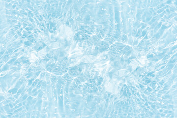 Blue water with ripples on the surface. Defocus blurred transparent blue colored clear calm water surface texture with splashes and bubbles. Water waves with shining pattern texture background.