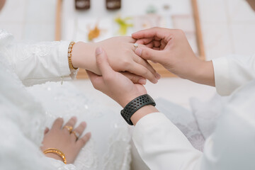 Groom wear wedding rings to left finger of bride, Muslim wedding, malaysia , Indonesia ,Wedding Poster, Close up hand.