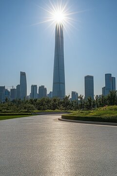 Tianjin CTF Finance Centre shines in bright sunlight from below with park in foreground China