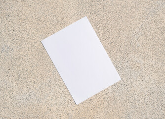 Fototapeta premium empty vertical paper poster mockup on concrete stone floor or pavement outdoors