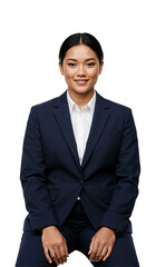Young adult Asian businesswoman in a dark blue formal suit and white collared shirt, sitting and smiling confidently at the camera against a plain black studio background.