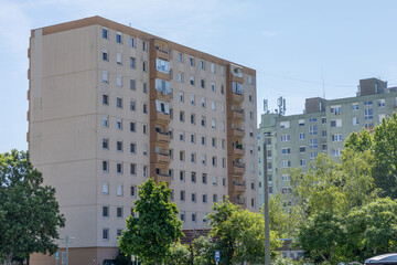 Ten-storey residential panel building surrounded by trees.