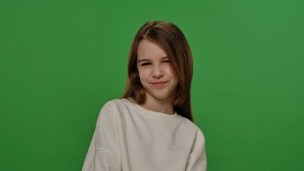 Obraz premium Teenage girl posing at camera, positive expression, isolated on chroma key green screen studio background mockup.