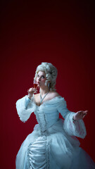Noble ritual. Woman drinks from wineglass in dramatic pose, capturing spirit of historical elegance...