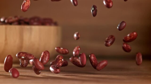 Red beans fall on the table. Filmed on a high-speed camera at 1000 fps. High quality FullHD footage