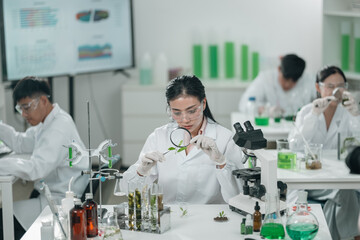 Scientists examining plant and algae samples in a modern laboratory, conducting pharmaceutical...