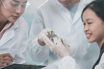 Scientists examining plant and algae samples in a modern laboratory, conducting pharmaceutical...