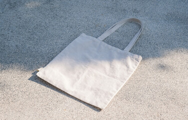 Tote bag mockup template on concrete stone background with deep sunlit shadows