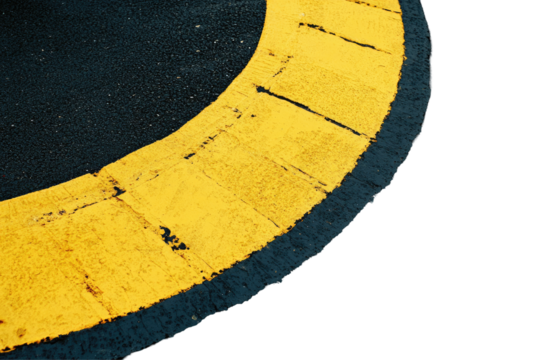 Worn yellow pavement markings curve on dark asphalt