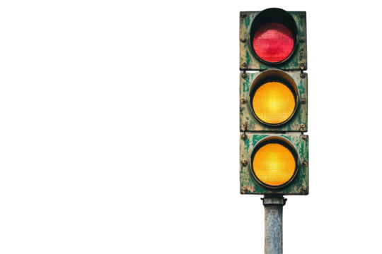 A weathered traffic signal displays a red and two amber lights