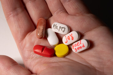 A person holds substances, drugs and pills in his hand. the concept of addiction and the pursuit of...