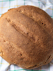 Homemade loaf of whole grain bread on kitchen table. Top view. Close-up.