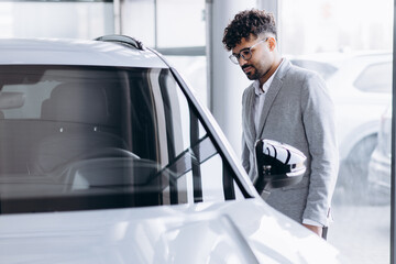 Business man choosing a car in car salon