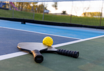 two pickleball paddles on court at local park 