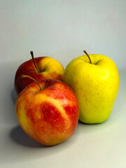 Colorful apples arranged artistically on a neutral background, showcasing vibrant red and yellow hues