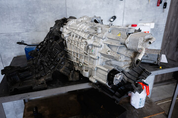Close-up of an automotive transmission on a metal workbench in a garage