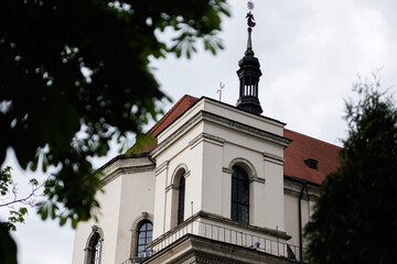 Historic building with rooftop spire surrounded by trees on a cloudy day in Lviv, Ukraine.