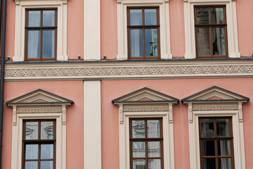 Fototapeta premium Elegant facade with symmetrical decorated windows and architectural details in Lviv, Ukraine.