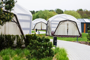 Outdoor modern dome tents surrounded by greenery in a peaceful setting