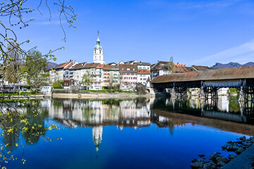 Fototapeta premium Olten, Stadt, Stadtturm, Aare, Fluss, Uferweg, Flussufer, Holzbrücke, Altstadt, Frühling, Frühlingssonne, Frühlingsblüten, Solothurn, Schweiz