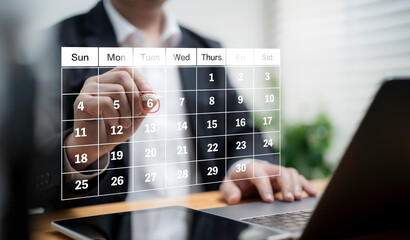 Businessman marking digital calendar date