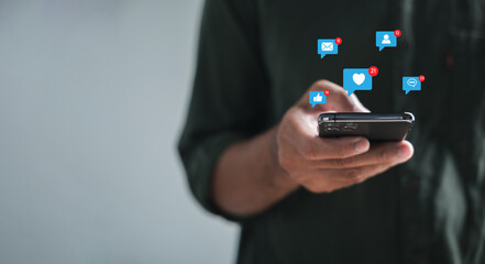 Using his smartphone, man types in live chat, embodying concepts of chatting and social networking. Working within chat box icons, he symbolizes technology-driven concept of social medimarketing.