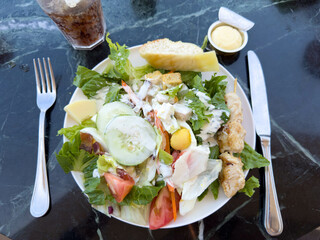 A Salad on a marble table at an outdoor restaurant on a cruise ship.