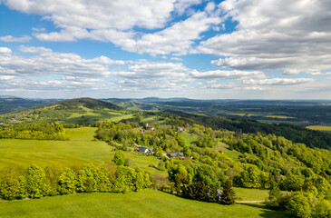 Obraz premium Aerial view of blooming summer landscape near Jizera Mountains with green hills, forests, meadows and picturesque villages, including views toward Jested mountain in Czech Republic