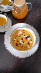 Delicious homemade pumpkin soup. Orange pumpkin soup with seeds in a round bowl.