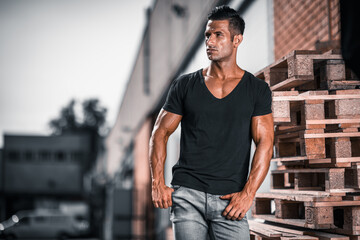 handsome athletic young man standing on the street