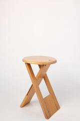 Small, folding, used wooden stool that can also serve as a side table,.