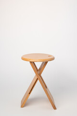 Small, folding, used wooden stool that can also serve as a side table,.