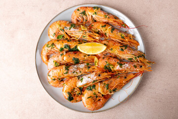 Langoustines fried in butter with garlic and parsley. Served with a slice of lemon. Traditional Mediterranean cuisine. A popular appetizer in restaurants and pubs. Homemade cooking. Selective focus.