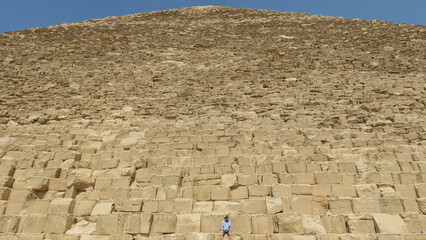 Explore the grandeur of an ancient Egyptian pyramid.  Magnificent stone blocks under a clear sky.