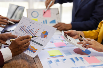 Business team analyzing financial data using graph and chart in office meeting. Focused on...