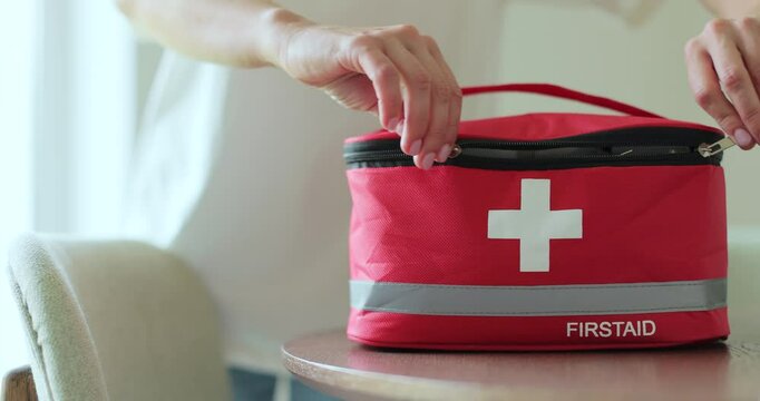Woman takes out blister of pills from first aid kit at home.