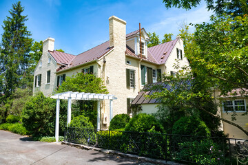 An old brick mansion in the American Colonial style. Fireplace chimneys and pergola at the entrance.