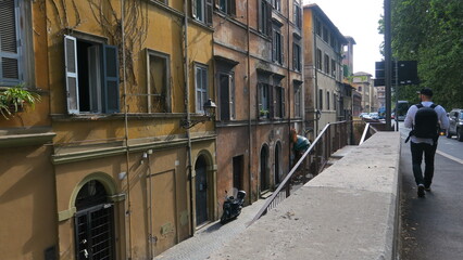 Picturesque Roman street scene with historic buildings and a pedestrian walking by.