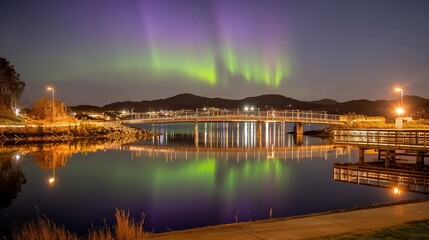 Obraz premium Breathtaking Northern Lights Illuminating Lake and Bridge at Night Under Starry Sky
