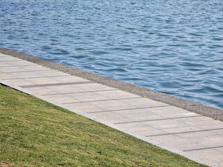 walkway between the lake and grassland in the park