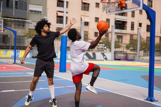 African men playing basketball in the city during summer time - Sport, urban lifestyle and young people concept