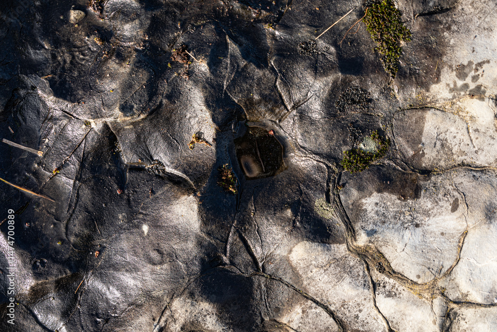 Poster High-resolution image of a dark grey rock surface with cracks and crevices. Ideal for backgrounds or textures.