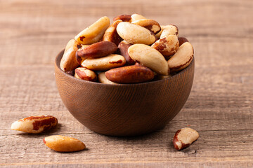 Brazil nuts in a wooden bowl. Healthy fats concept. 