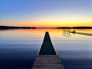 Colorful peaceful spring sunset on Big Marine Lake Minnesota, near Scandia, with dock in photo