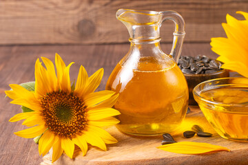Sunflower oil and sunflower seeds on traditional rustic wooden background. Organic and eco food concept. Healthy food and fats.